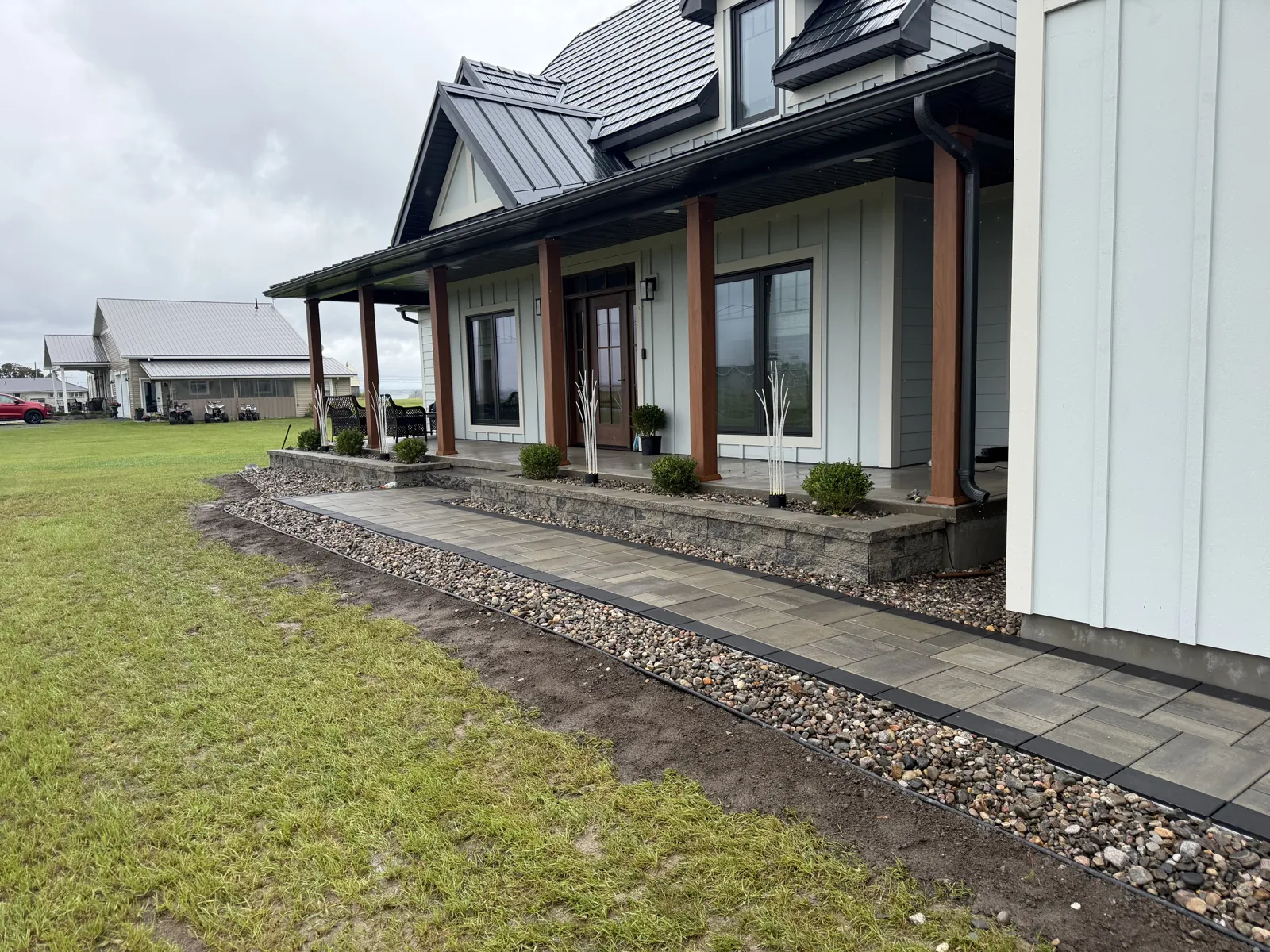 Covered porch with paver walkway and landscaping